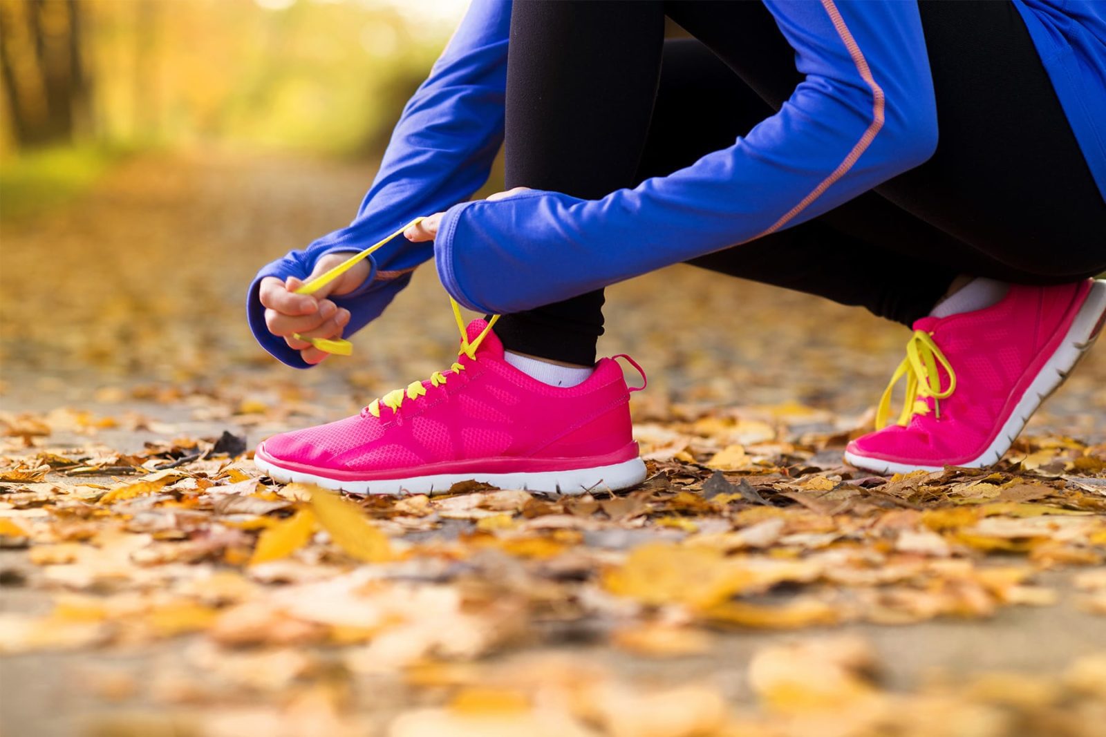 A woman tying laces on her running shoes