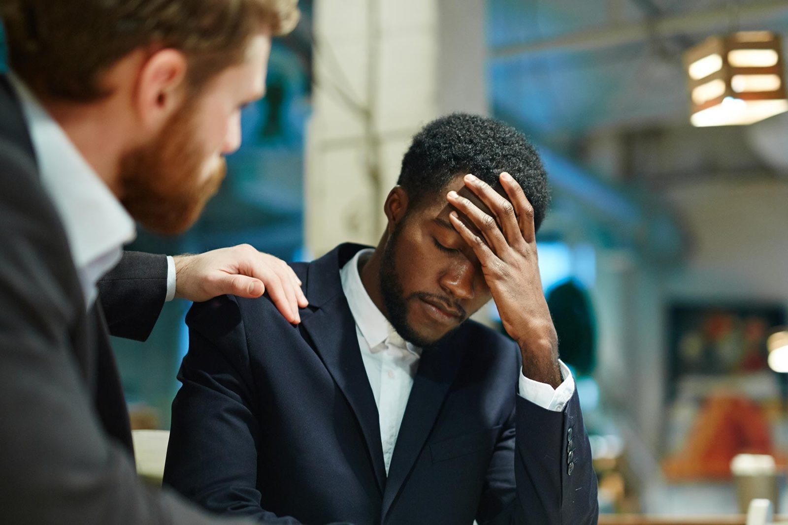 Man comforting his friend who is showing signs of self-harm behaviour