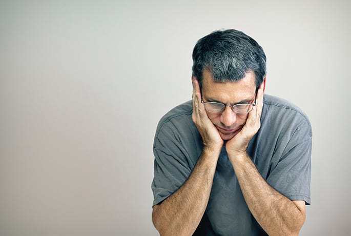 Man with head in hands having thoughts about ending his life