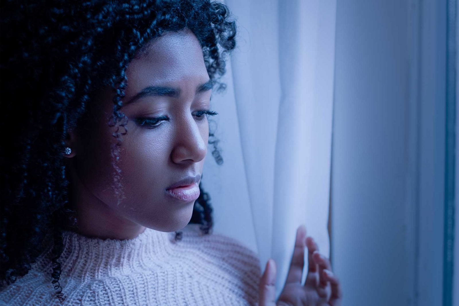 Grieving woman looking out a window