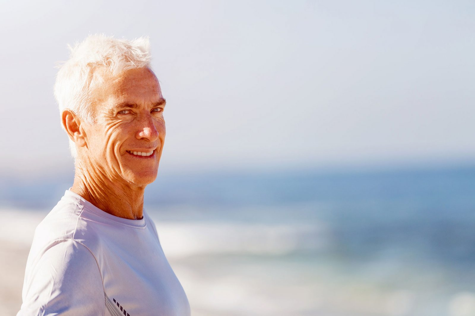 Man walking along a beach smiling