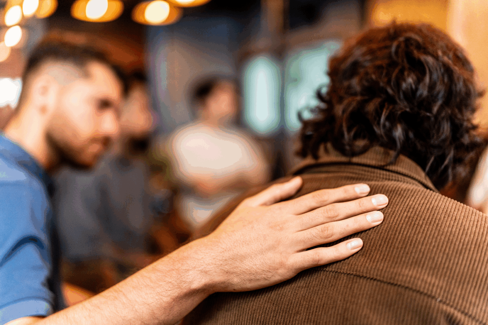 Man's hand on persons shoulder