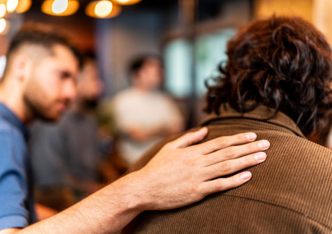 Man's hand on persons shoulder