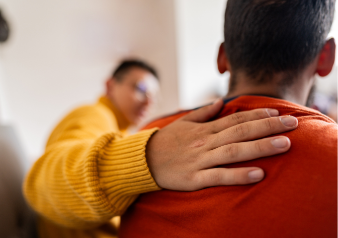 Man with hand on friends back, offering support