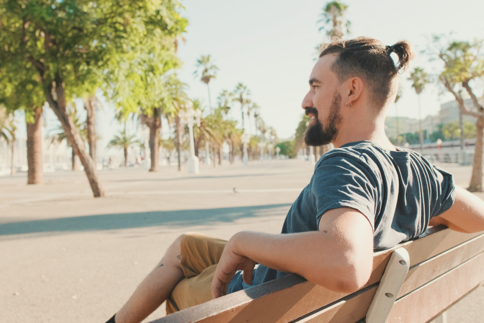 Young man sitting, resting on a bench