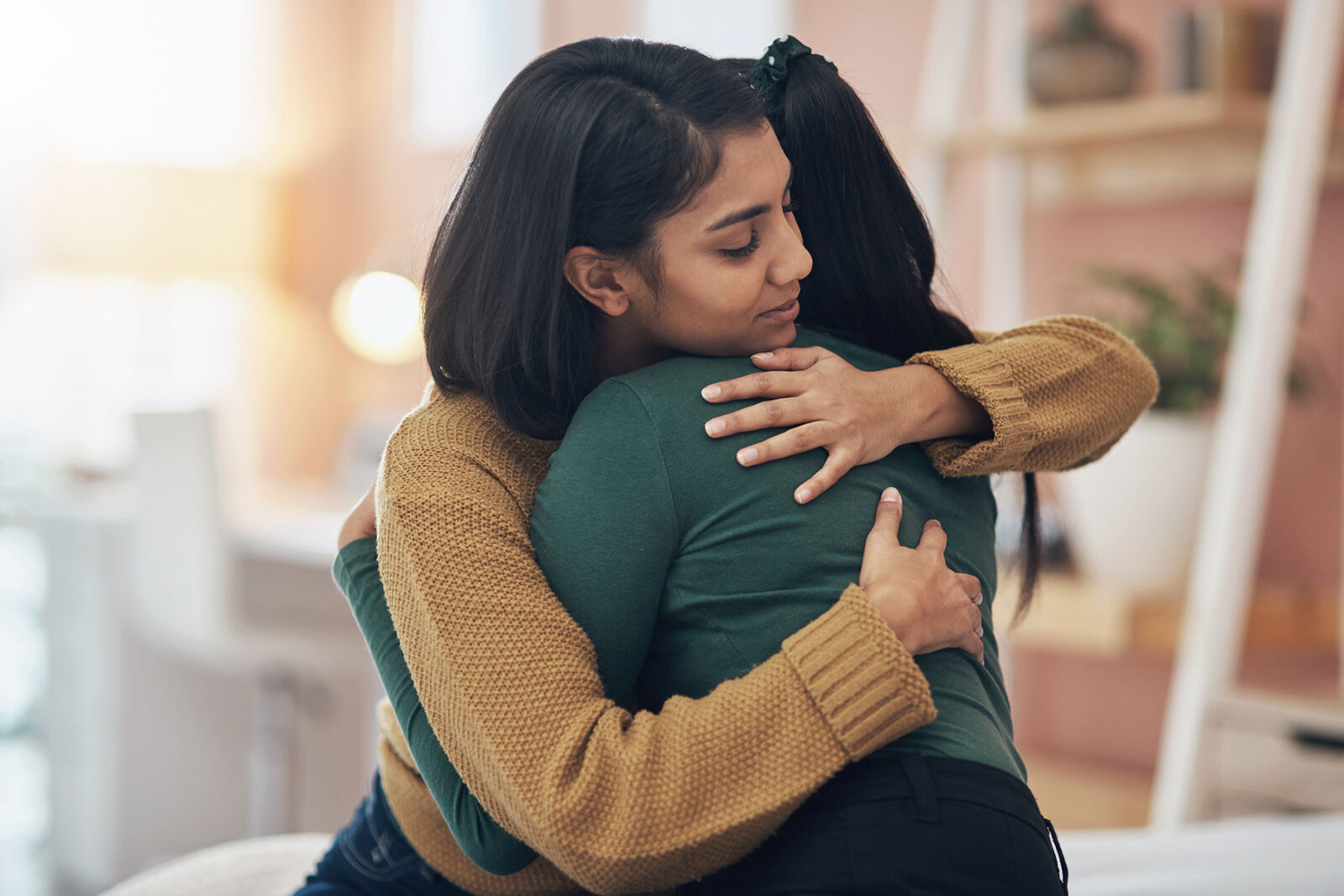 Two women hugging looking hopeful