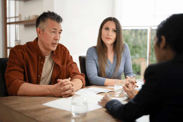 Three people sitting at a table in legal discussion